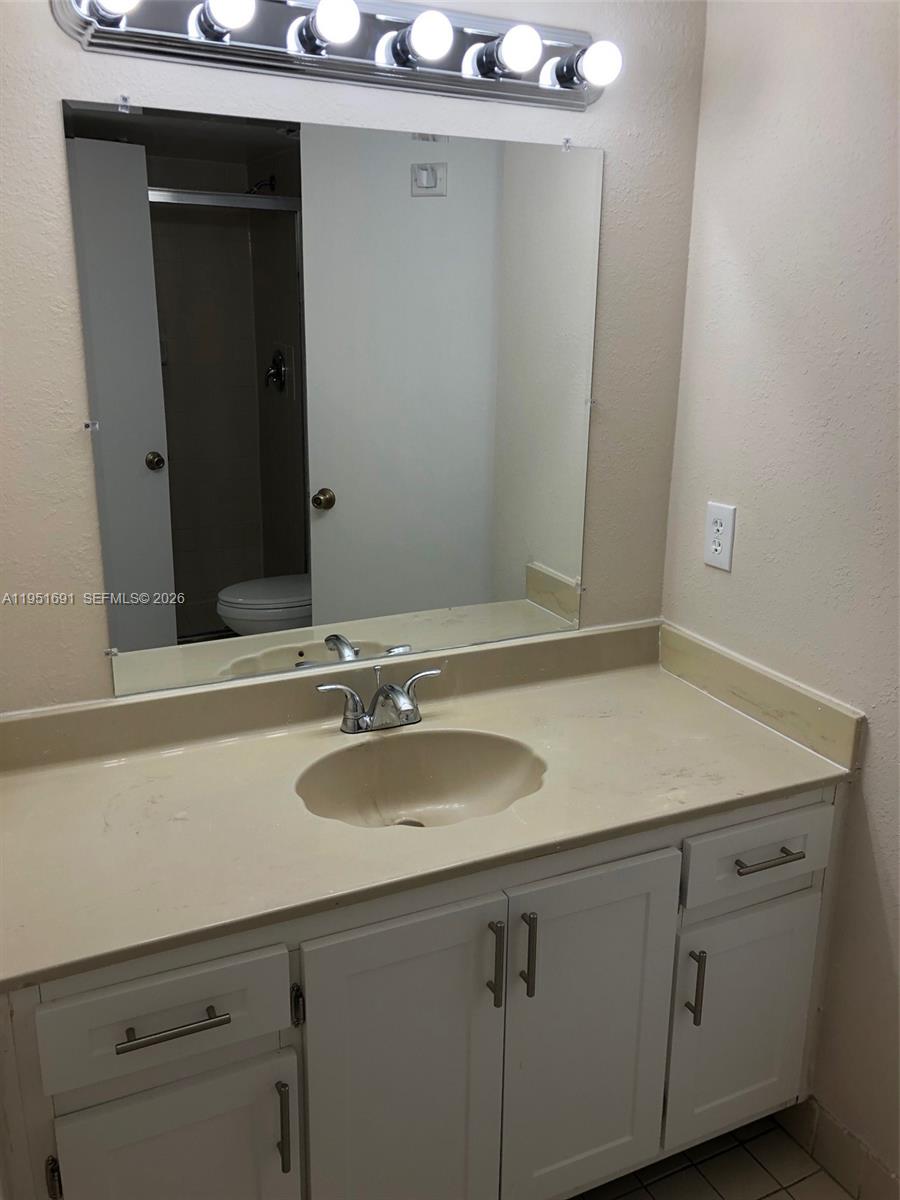 20840 San Simeon Way, Unit 702 Miami, FL 33179 - Photo 22 of 34 a bathroom with a sink and a mirror