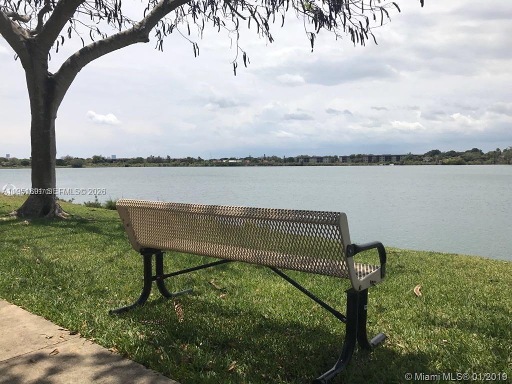 20840 San Simeon Way, Unit 702 Miami, FL 33179 - Photo 29 of 34 a view of a lake with a bench and lake view