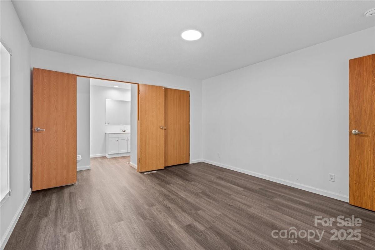 282 Bob Hardin Road Rutherfordton, NC 28139 - Photo 11 of 27 an empty room with wooden floor and windows