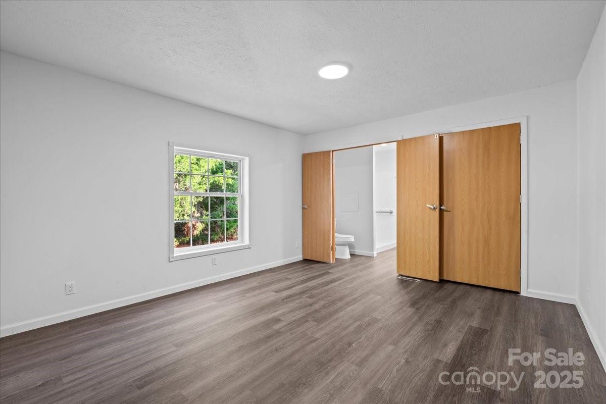 282 Bob Hardin Road Rutherfordton, NC 28139 - Photo 12 of 27 an empty room with wooden floor and windows