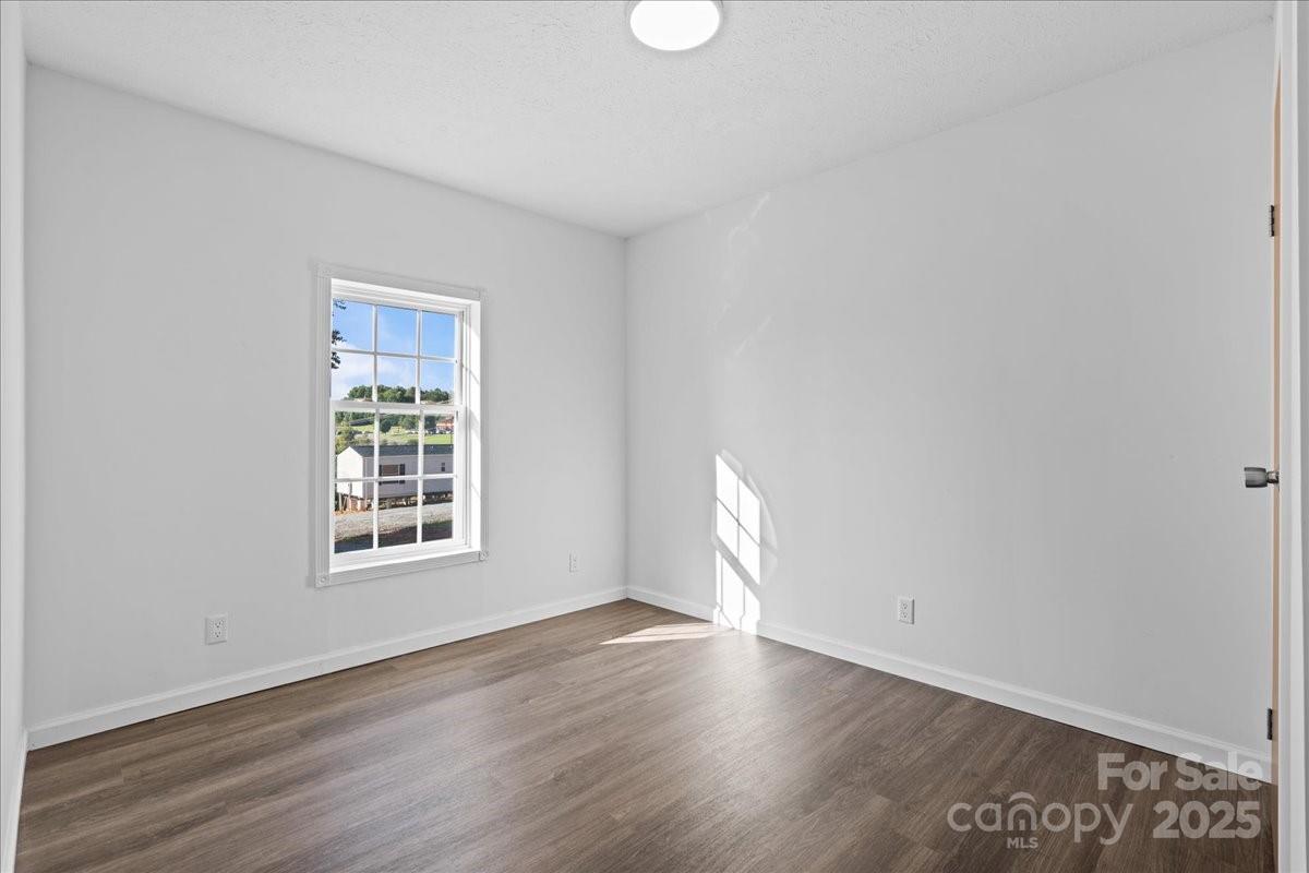 282 Bob Hardin Road Rutherfordton, NC 28139 - Photo 17 of 27 an empty room with wooden floor and windows