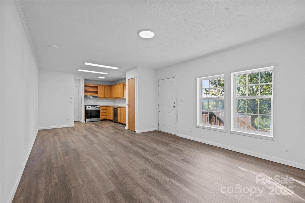 282 Bob Hardin Road Rutherfordton, NC 28139 - Photo 4 of 27 an empty room with wooden floor and windows