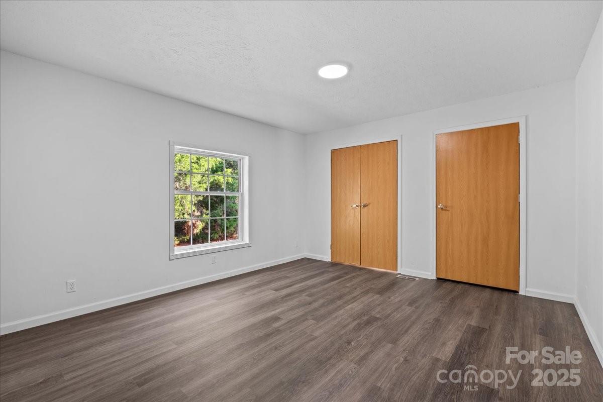 282 Bob Hardin Road Rutherfordton, NC 28139 - Photo 9 of 27 an empty room with wooden floor and windows