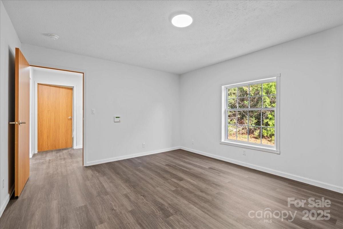 282 Bob Hardin Road Rutherfordton, NC 28139 - Photo 10 of 27 an empty room with wooden floor and windows