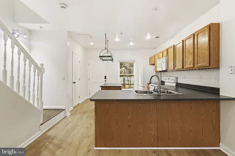 a kitchen with stainless steel appliances granite countertop a sink a stove and a refrigerator