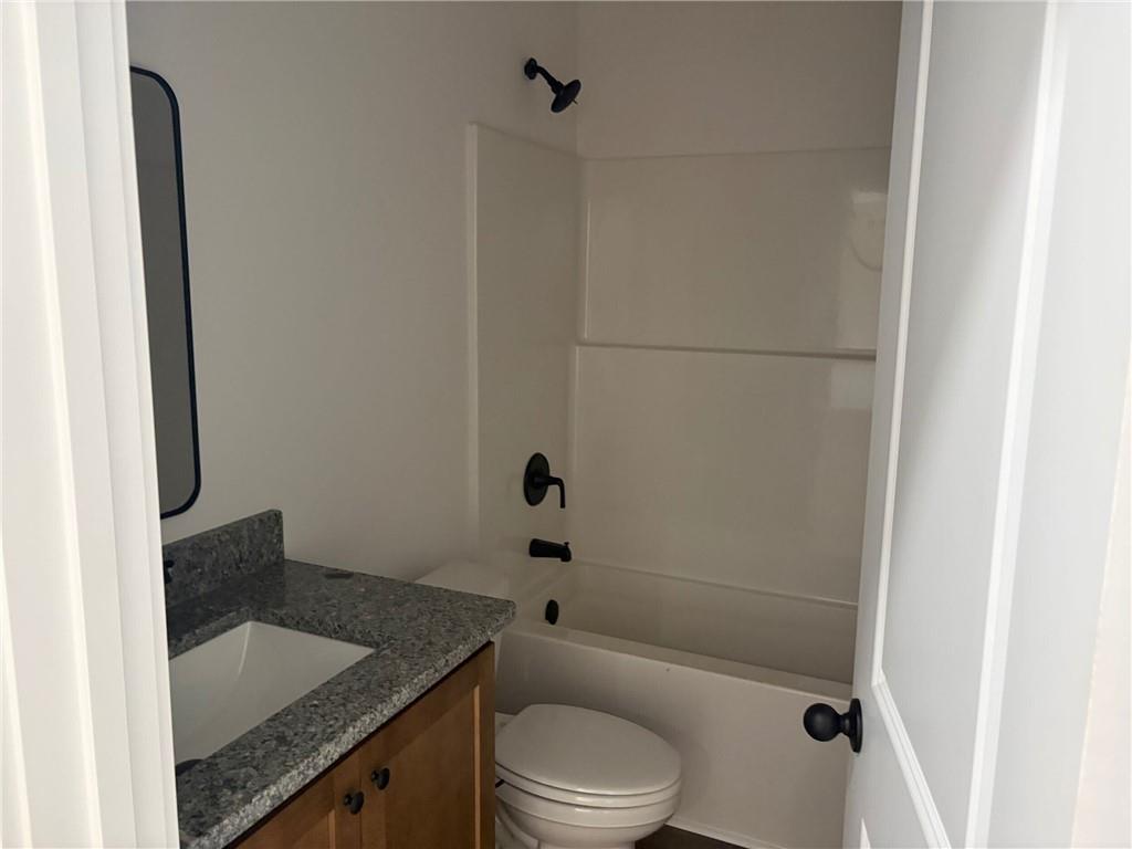 3216 South Phillips Road Lanett, AL 36863 - Photo 8 of 14 Bathroom featuring a vanity with a light wood-finish base, stone countertop, and an undermount sink
