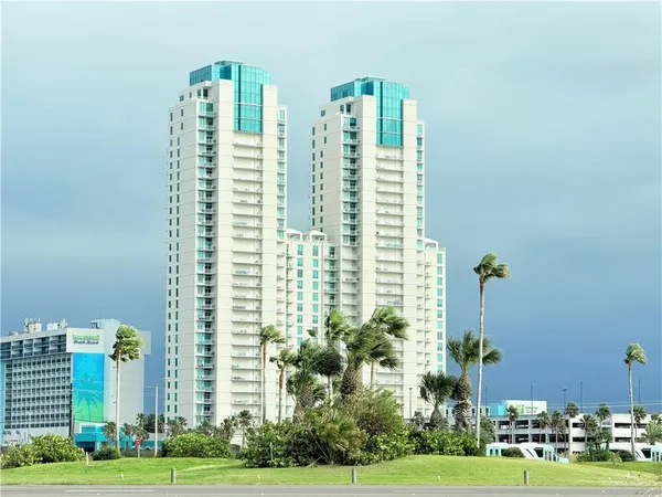 a multi story building with trees in front of it