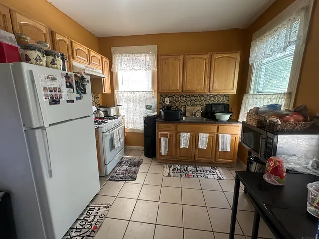 a kitchen with a refrigerator a stove a washer and dryer next to a window