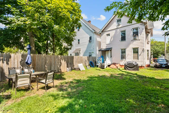 a view of a house with backyard and sitting area