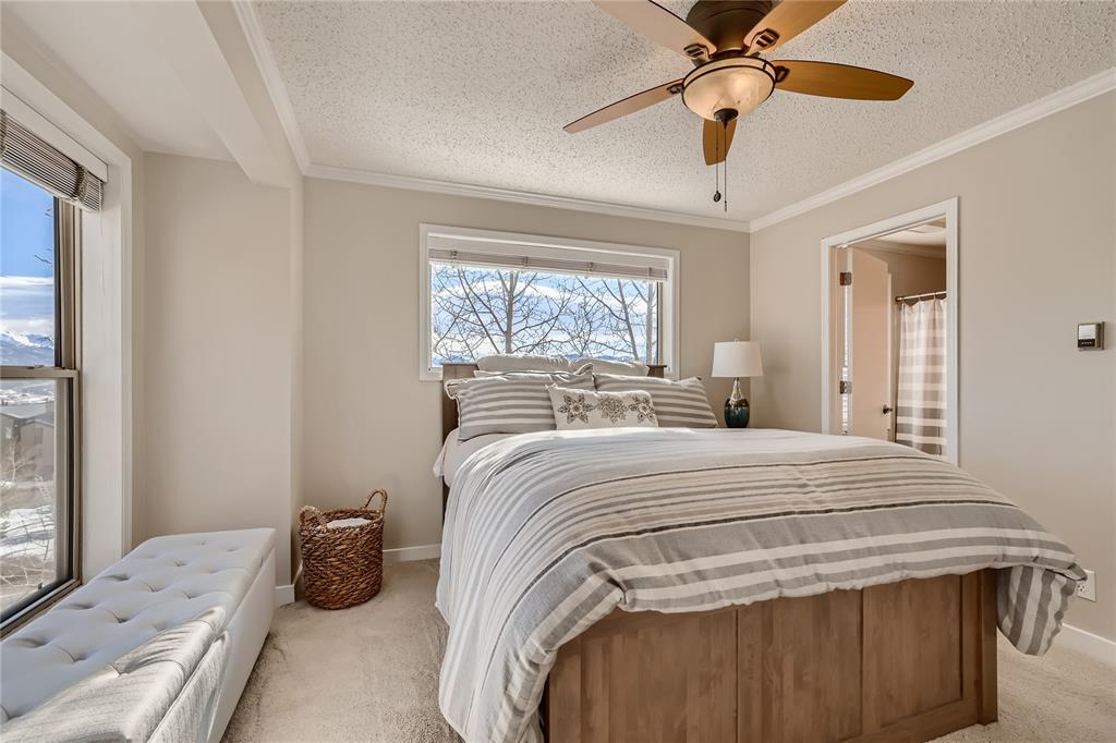 263 Saddle Ridge Drive, Unit 263 Silverthorne, CO 80498 - Photo 14 of 25 a bedroom with a bed and a chandelier