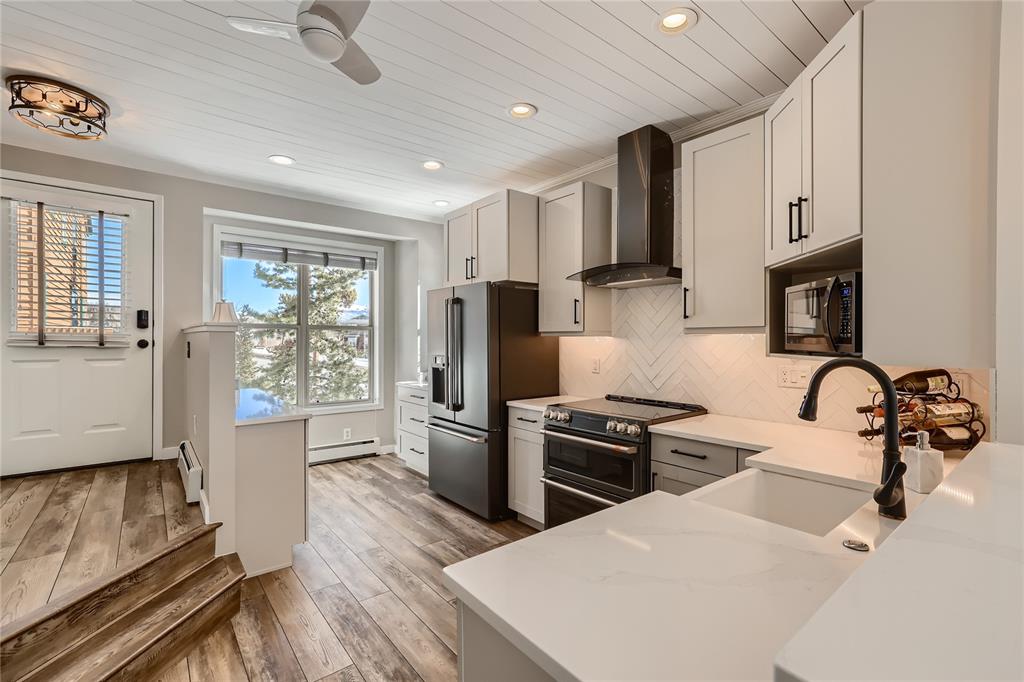 263 Saddle Ridge Drive, Unit 263 Silverthorne, CO 80498 - Photo 2 of 25 a kitchen with stainless steel appliances kitchen island granite countertop a stove and a refrigerator