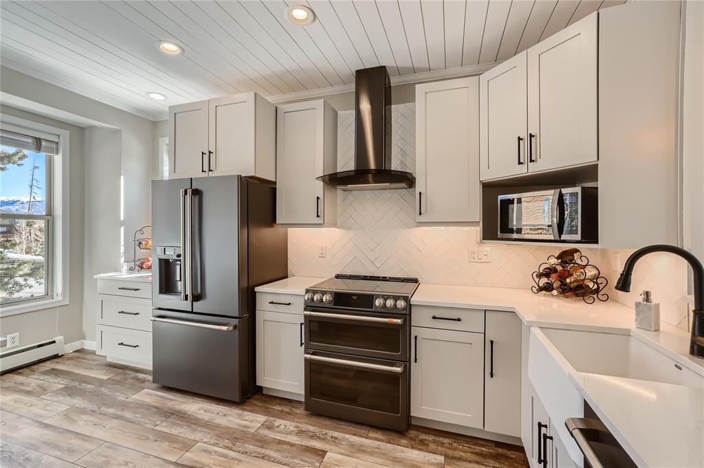 263 Saddle Ridge Drive, Unit 263 Silverthorne, CO 80498 - Photo 4 of 25 a kitchen with white cabinets and stainless steel appliances