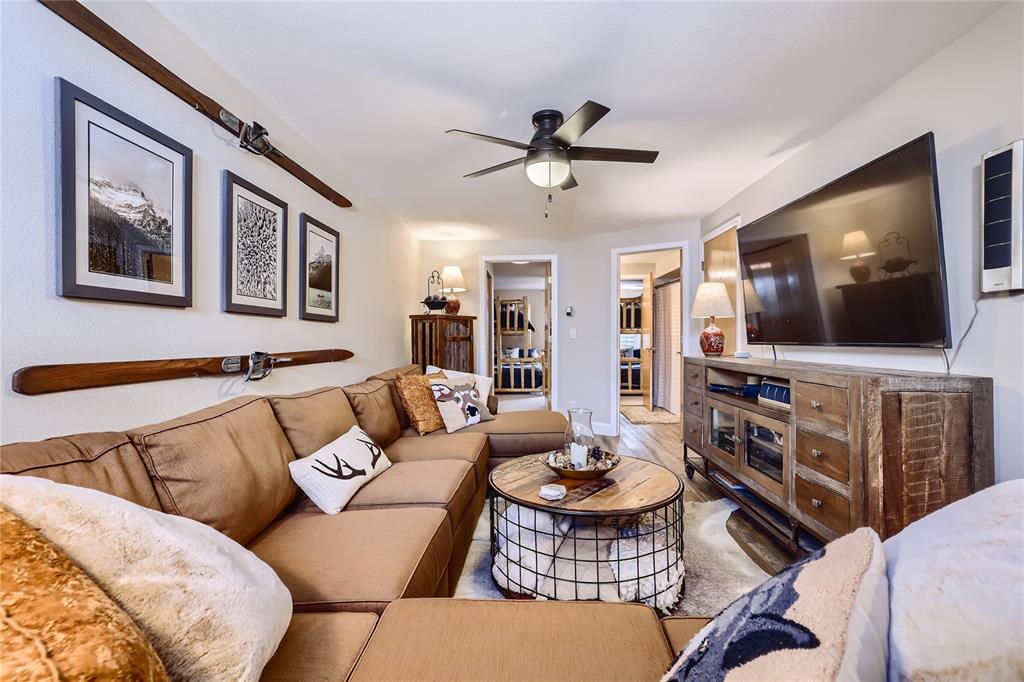 263 Saddle Ridge Drive, Unit 263 Silverthorne, CO 80498 - Photo 9 of 25 a living room with furniture a flat screen tv and kitchen view