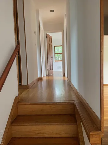an empty room with wooden floor and a window