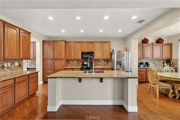 a kitchen with kitchen island granite countertop a stove and a sink