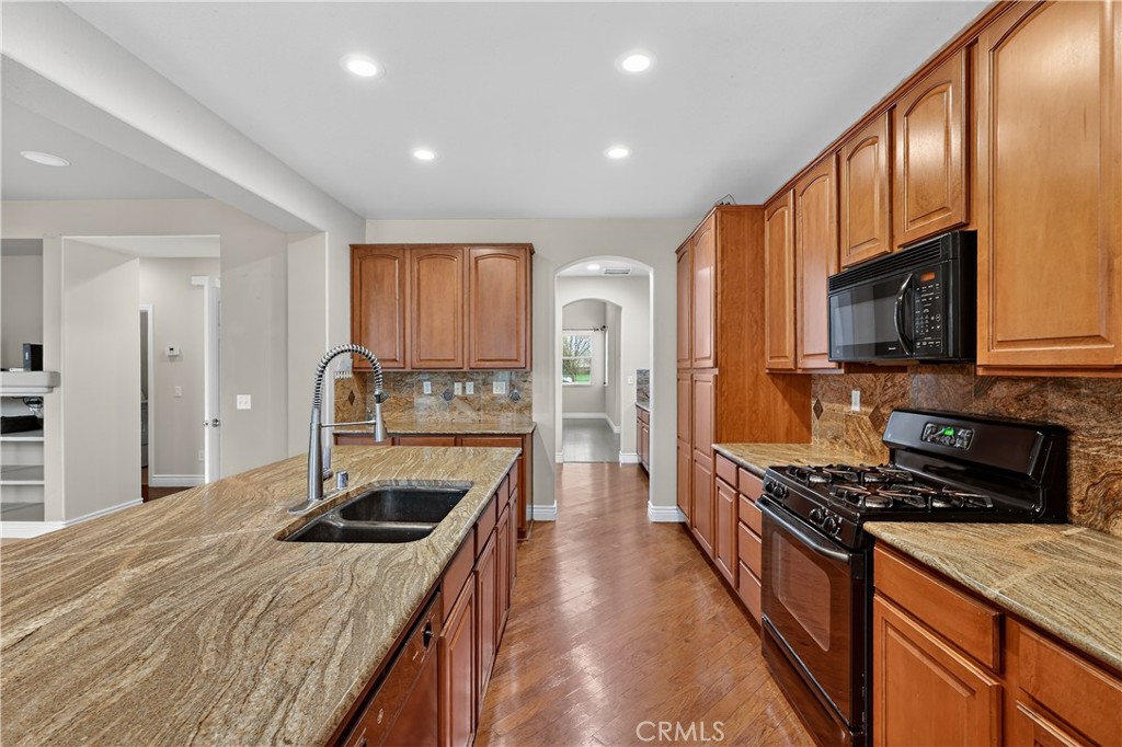 1277 Baxter Drive Merced, CA 95348 - Photo 15 of 63 a kitchen with stainless steel appliances granite countertop a sink stove microwave and refrigerator