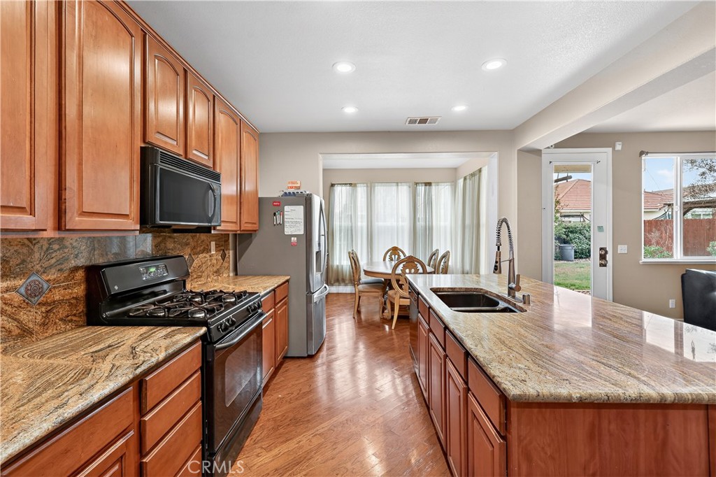 1277 Baxter Drive Merced, CA 95348 - Photo 16 of 63 a kitchen with kitchen island granite countertop a stove and a sink