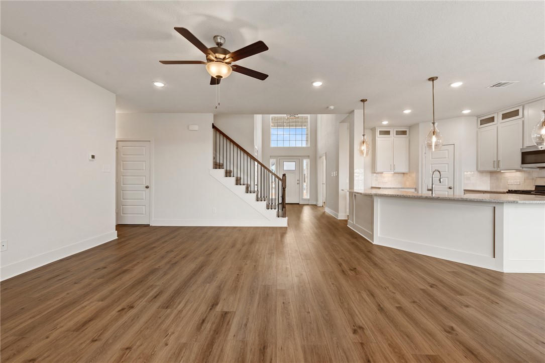 5626 Hayduke Ln. Bryan, TX 77802 - Photo 16 of 49 a view of a kitchen with wooden floor and a ceiling fan