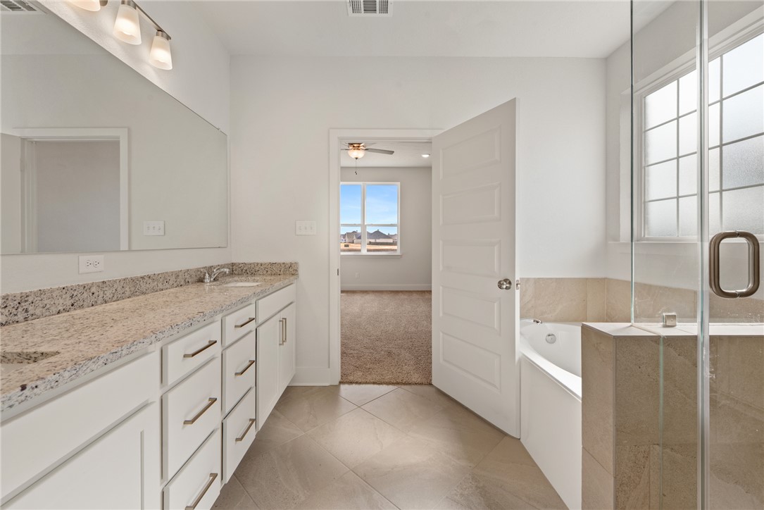 5626 Hayduke Ln. Bryan, TX 77802 - Photo 24 of 49 a bathroom with a granite countertop sink a toilet and shower