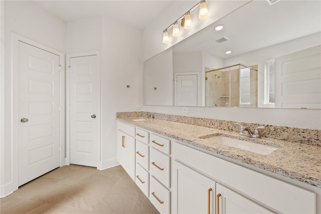 5626 Hayduke Ln. Bryan, TX 77802 - Photo 26 of 49 a bathroom with a granite countertop sink and a mirror