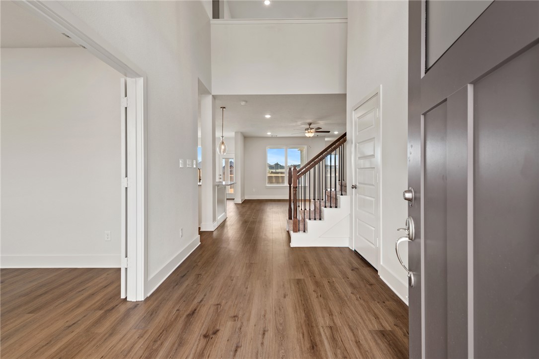 5626 Hayduke Ln. Bryan, TX 77802 - Photo 3 of 49 a hallway with wooden floor table and chairs