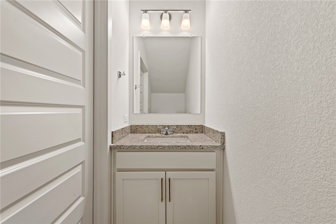 5626 Hayduke Ln. Bryan, TX 77802 - Photo 46 of 49 a bathroom with a granite countertop sink and a mirror