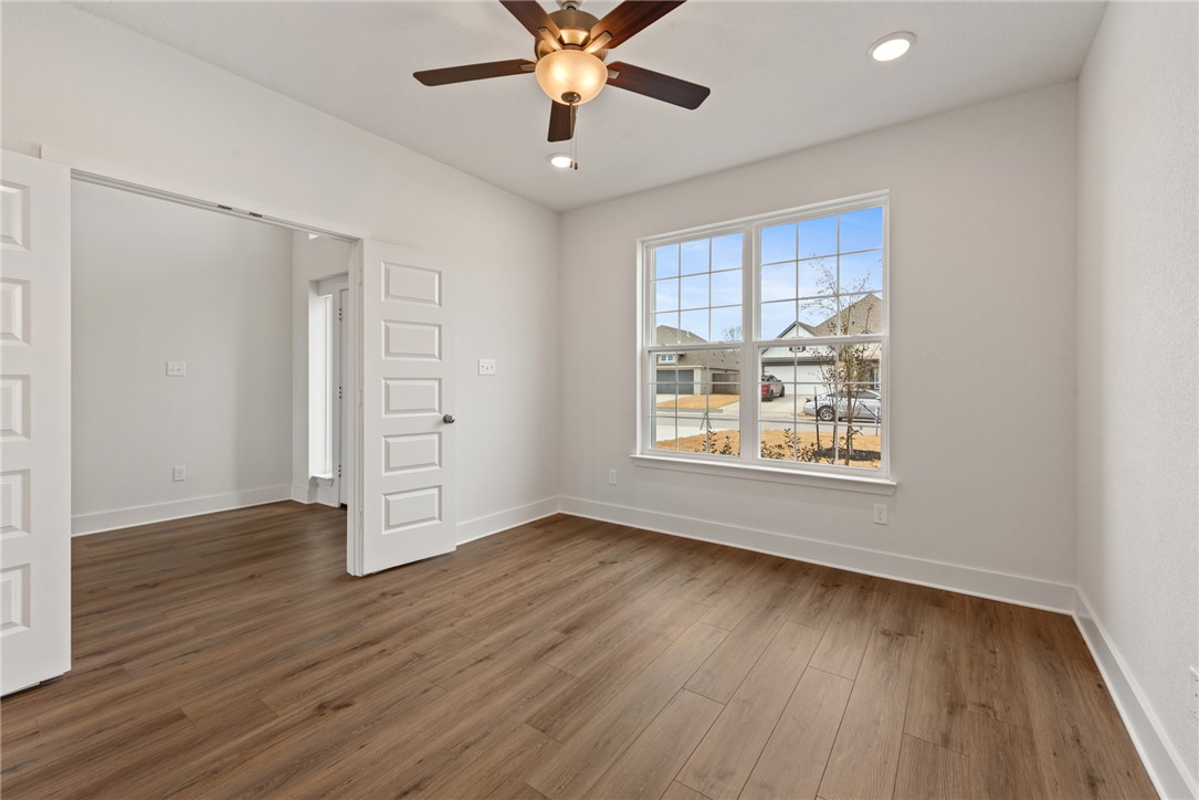 5626 Hayduke Ln. Bryan, TX 77802 - Photo 6 of 49 an empty room with wooden floor chandelier fan and windows