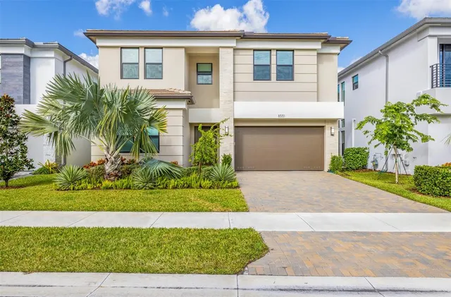 a front view of a house with a garden and yard