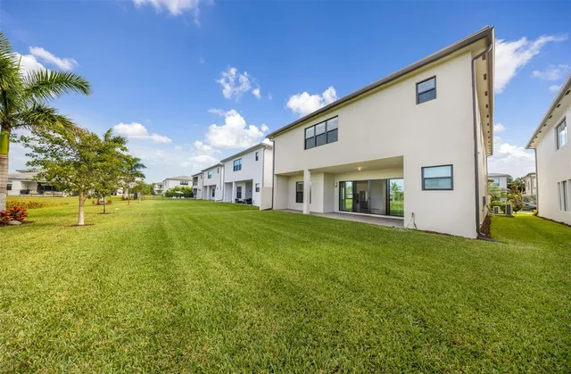 a view of an house with backyard space and balcony