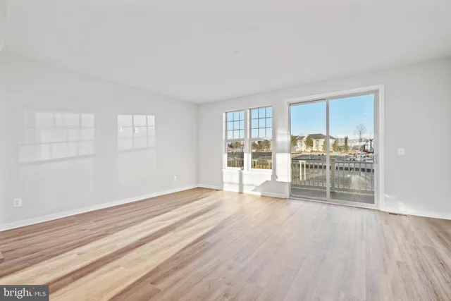 a view of empty room with wooden floor and fireplace