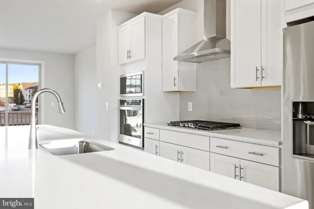 a kitchen with granite countertop a sink a stove and cabinets