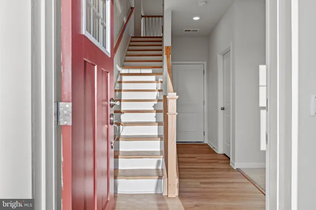a view of a hallway with wooden floor and entryway