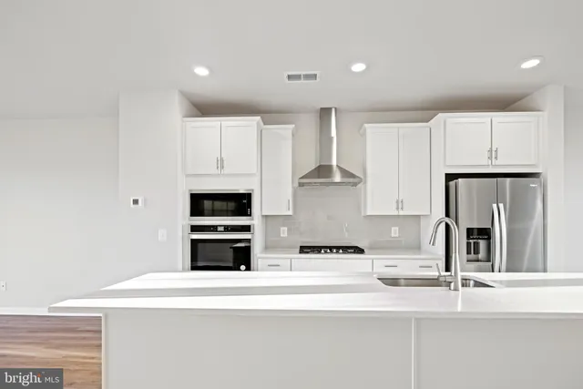 a kitchen with granite countertop white cabinets and stainless steel appliances