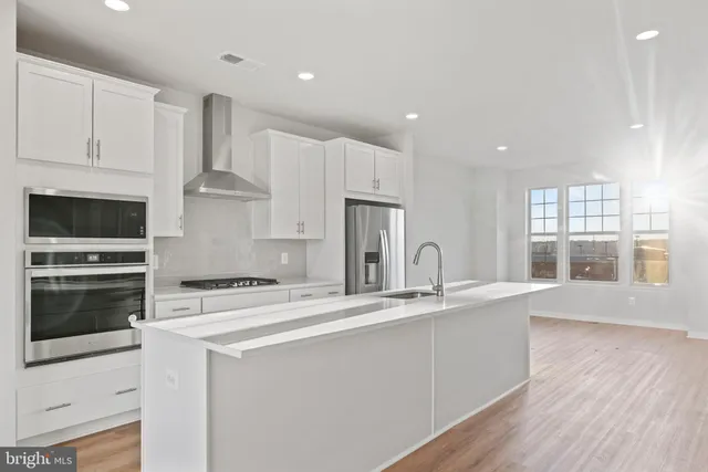 a kitchen with stainless steel appliances granite countertop a stove a sink and a refrigerator