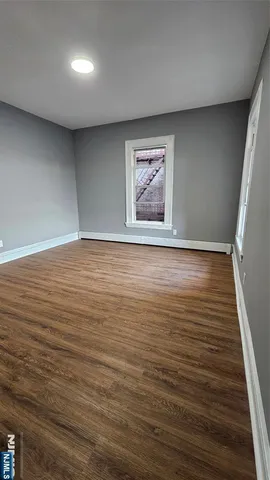 a view of a room with an empty space and wooden floor