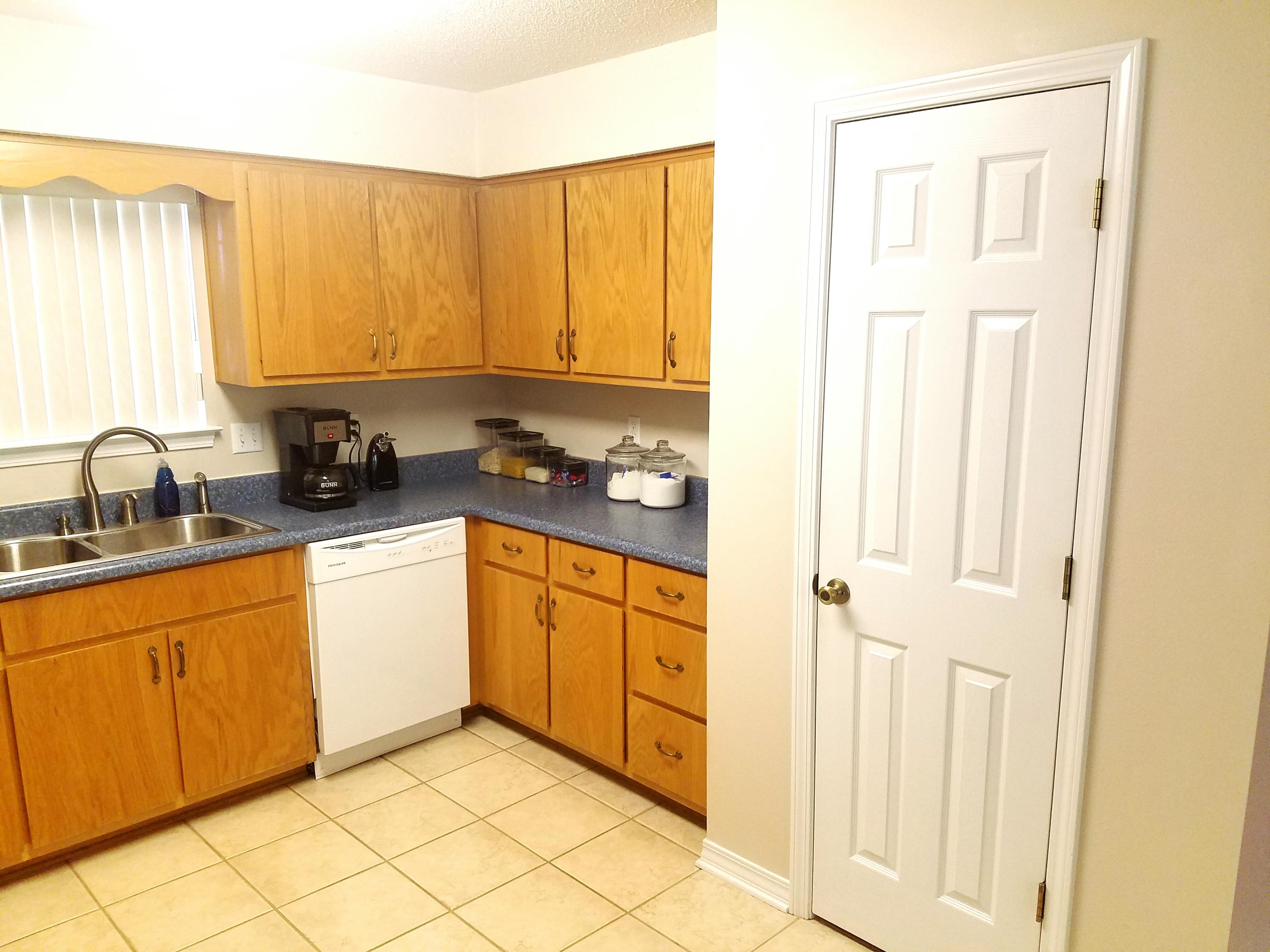 6298 Possum Ridge Road Crestview, FL 32539 - Photo 8 of 43 a kitchen with a sink a refrigerator and cabinets