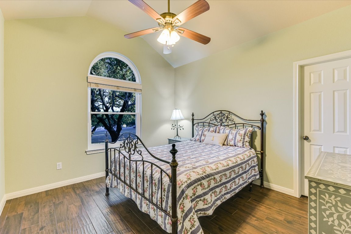 786 Ranchers Club Lane Driftwood, TX 78619 - Photo 24 of 33 a bedroom with a bed and a chandelier