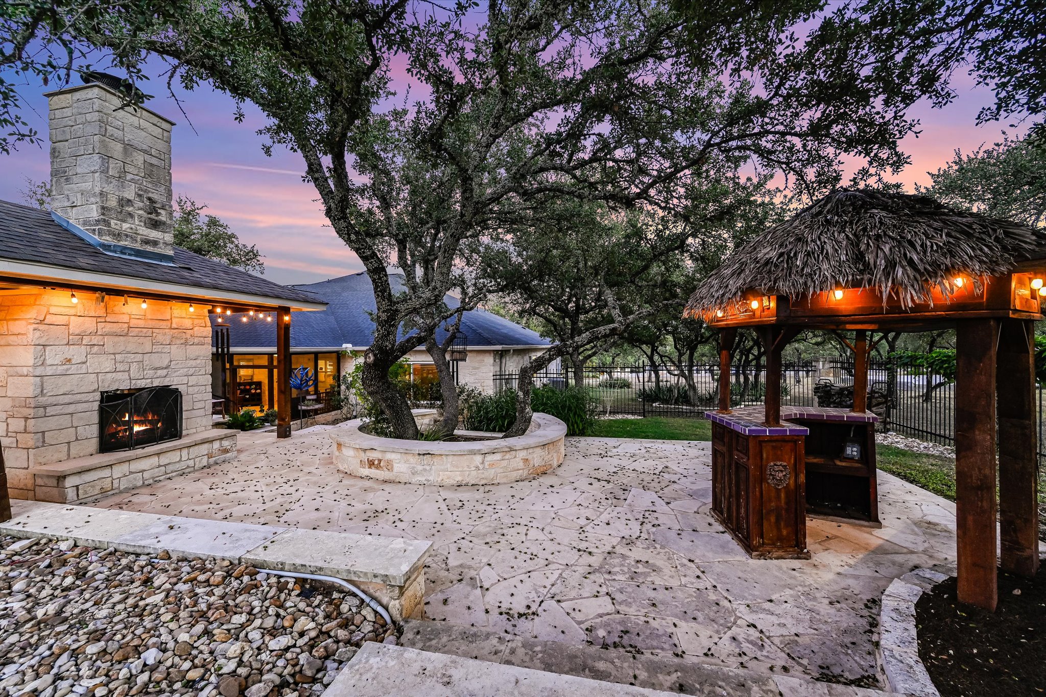 786 Ranchers Club Lane Driftwood, TX 78619 - Photo 26 of 33 Patio terrace at dusk with an outdoor stone fireplace and a patio area
