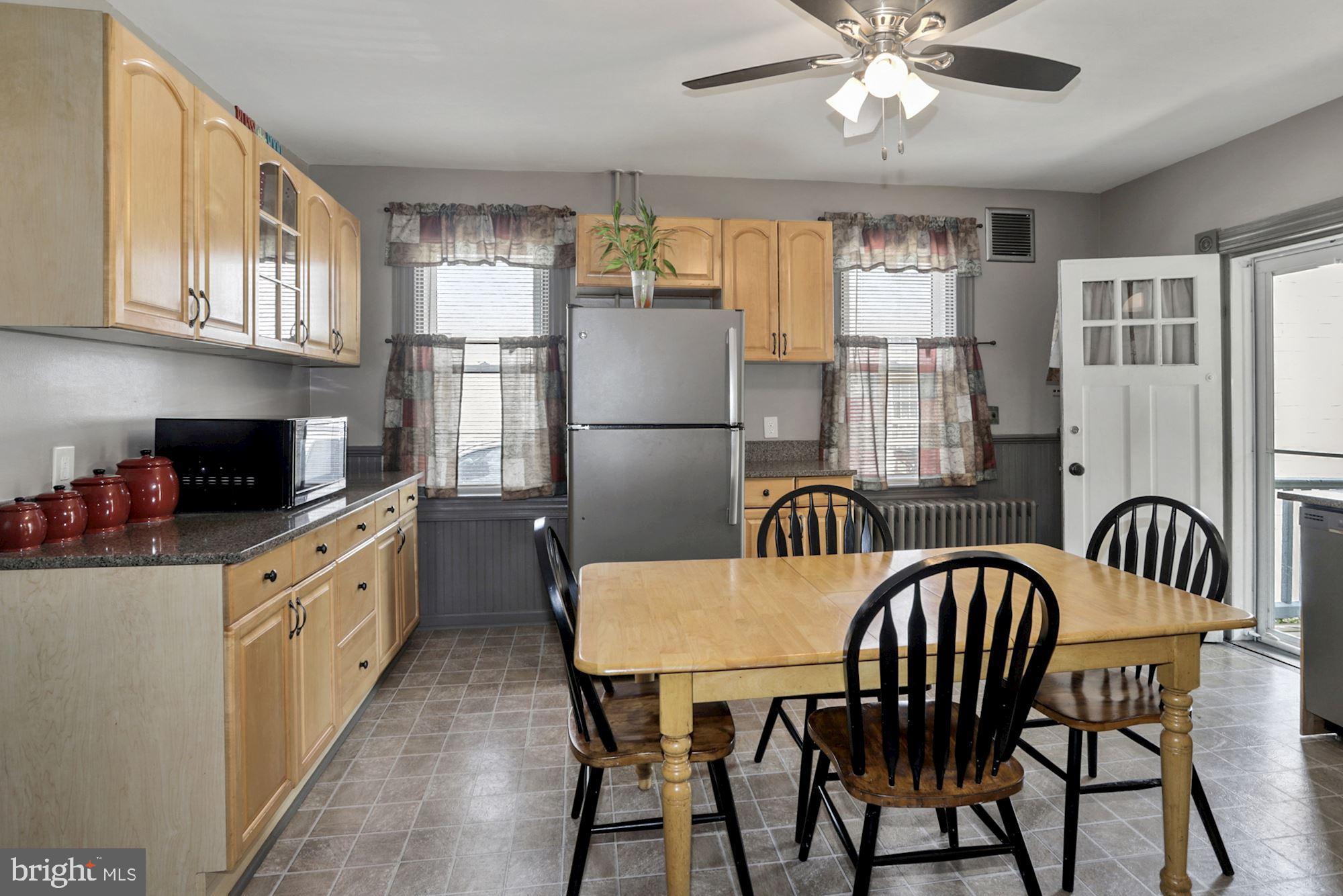 8029 Philadelphia Road Baltimore, MD 21237 - Photo 11 of 29 a kitchen with stainless steel appliances granite countertop a dining table chairs refrigerator and cabinets