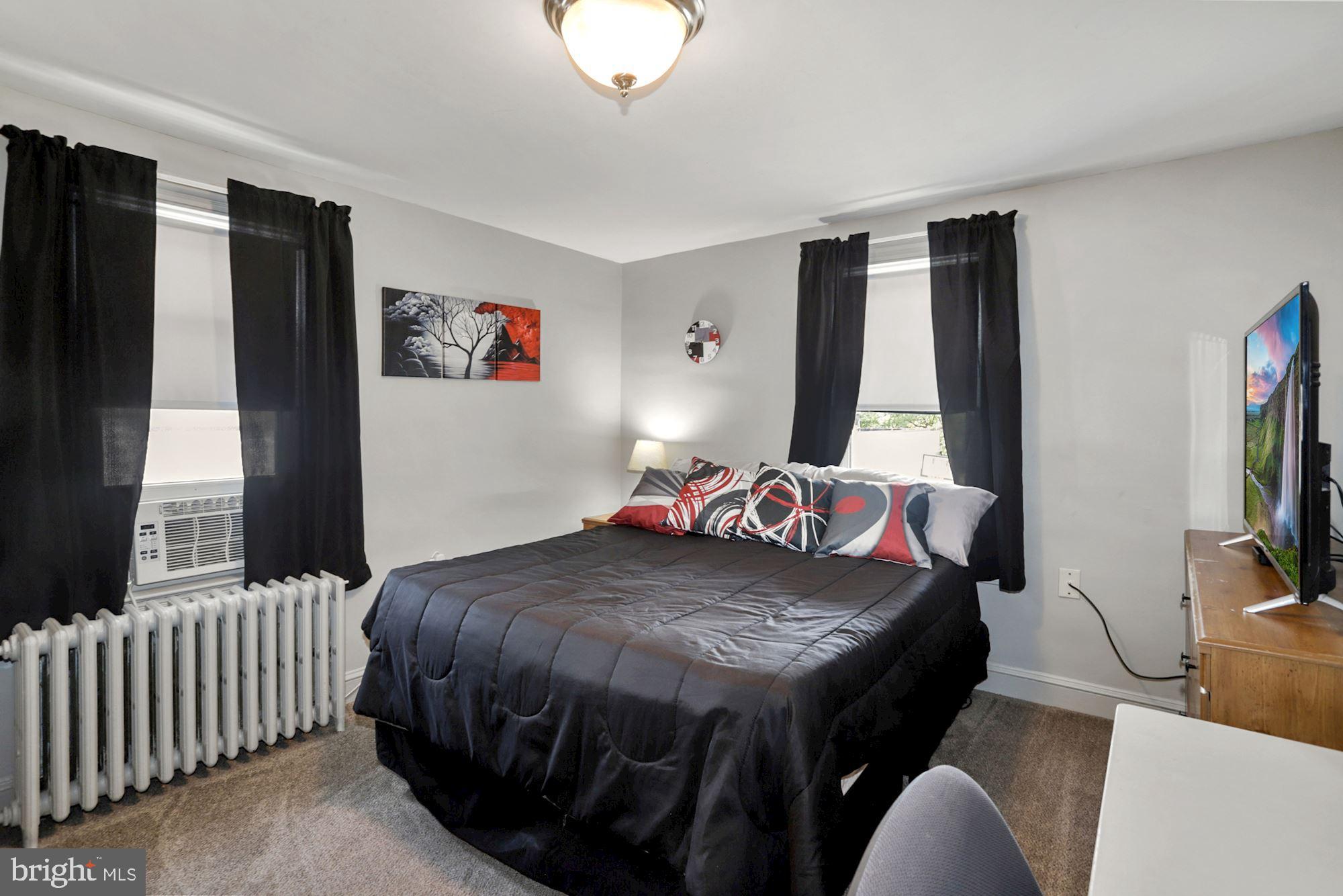 8029 Philadelphia Road Baltimore, MD 21237 - Photo 16 of 29 a bedroom with a bed and a flat screen tv