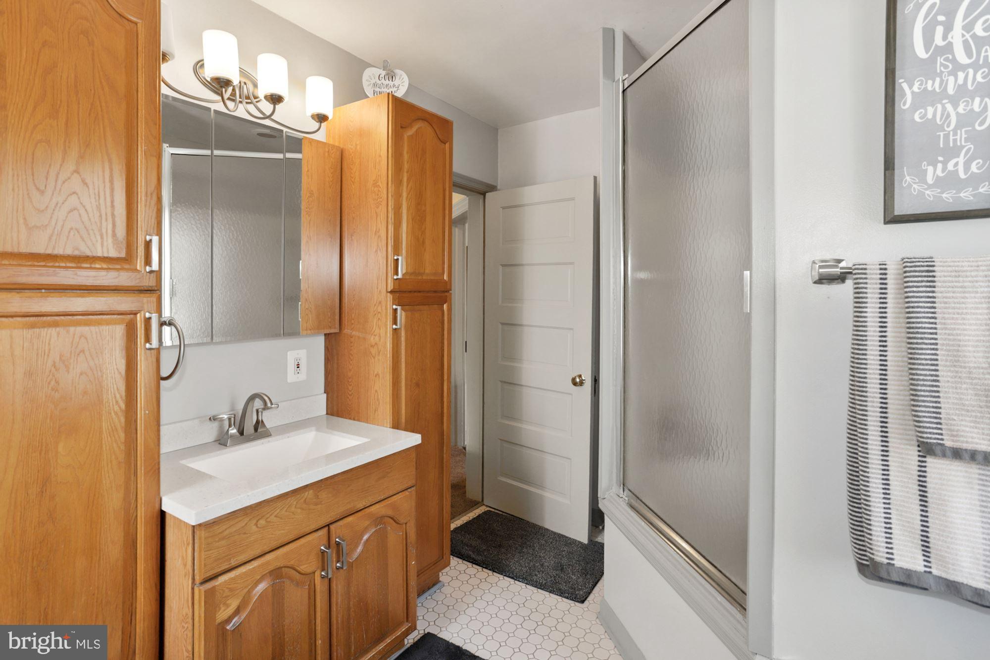 8029 Philadelphia Road Baltimore, MD 21237 - Photo 18 of 29 a bathroom with a double vanity sink mirror and shower