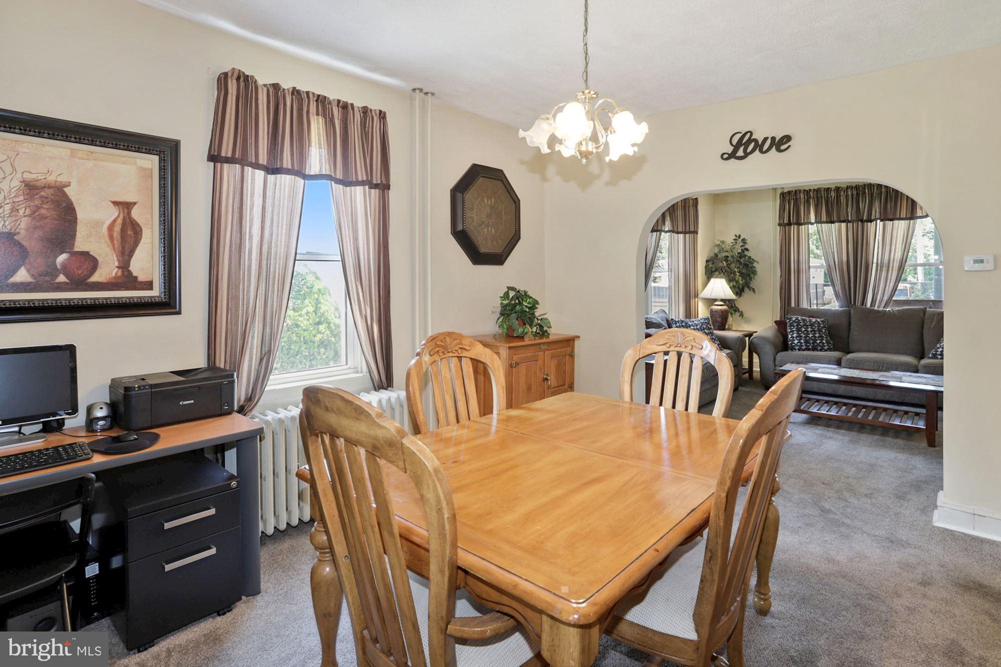 8029 Philadelphia Road Baltimore, MD 21237 - Photo 9 of 29 a dining room with wooden floor a chandelier a wooden table and chairs