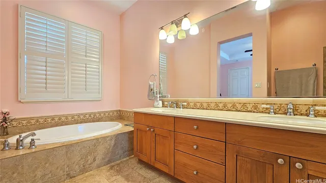 a bathroom with a double vanity sink toilet mirror and bathtub