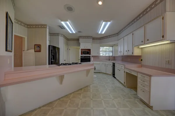 a large kitchen with kitchen island a sink stainless steel appliances and cabinets