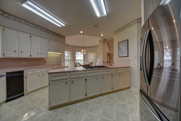 a kitchen with stainless steel appliances granite countertop a refrigerator sink and stove