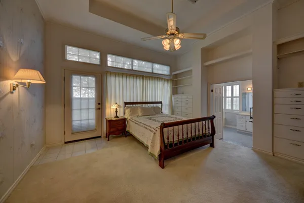 a spacious bedroom with a bed and a chandelier