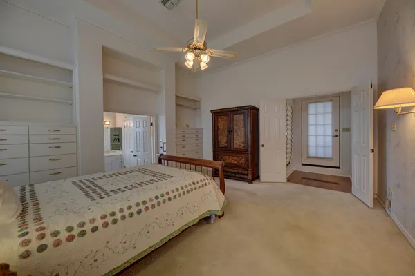 a spacious bedroom with a bed and a chandelier