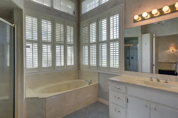 a bathroom with a bathtub and double sink