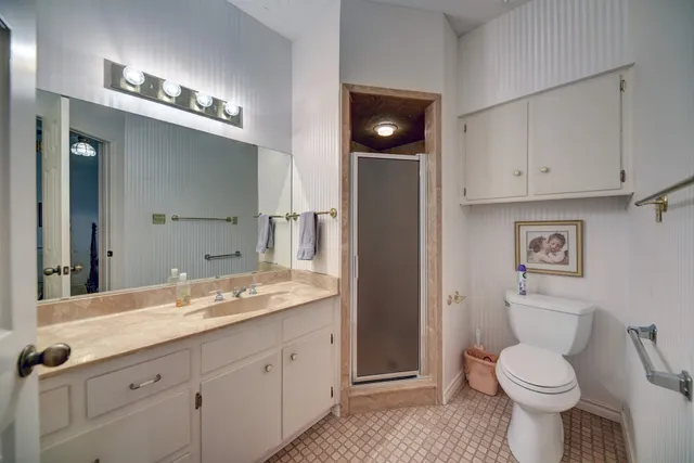 a bathroom with a granite countertop toilet sink and mirror