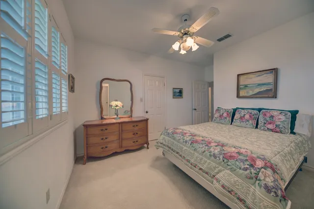 a bedroom with a large bed and a chandelier